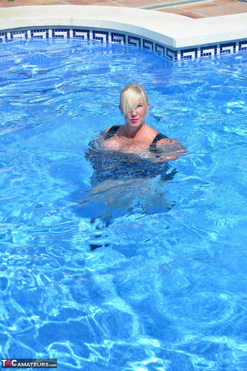 Thick blonde Melody displays her ample cleavage while fully clothed in a pool porn photo #426789636