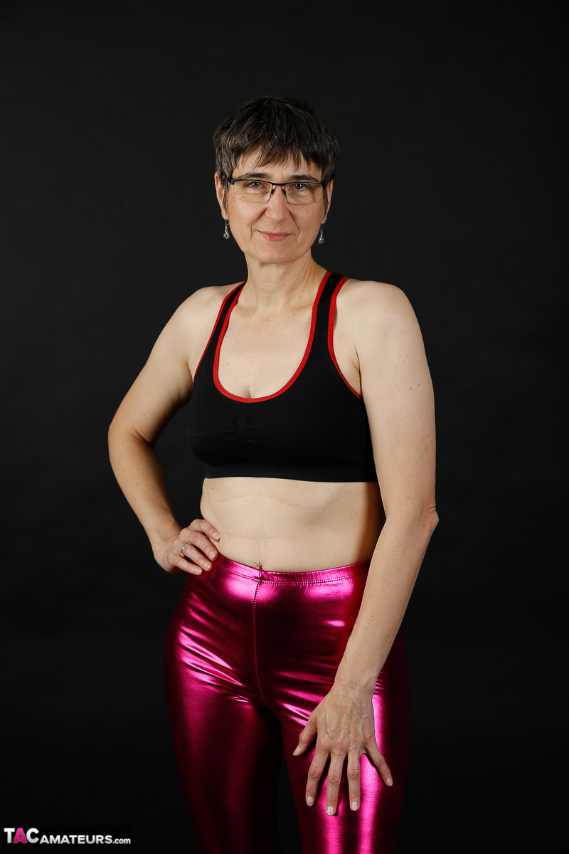 Mature woman models a sports bra in shiny pants and black boots foto pornográfica #428541772