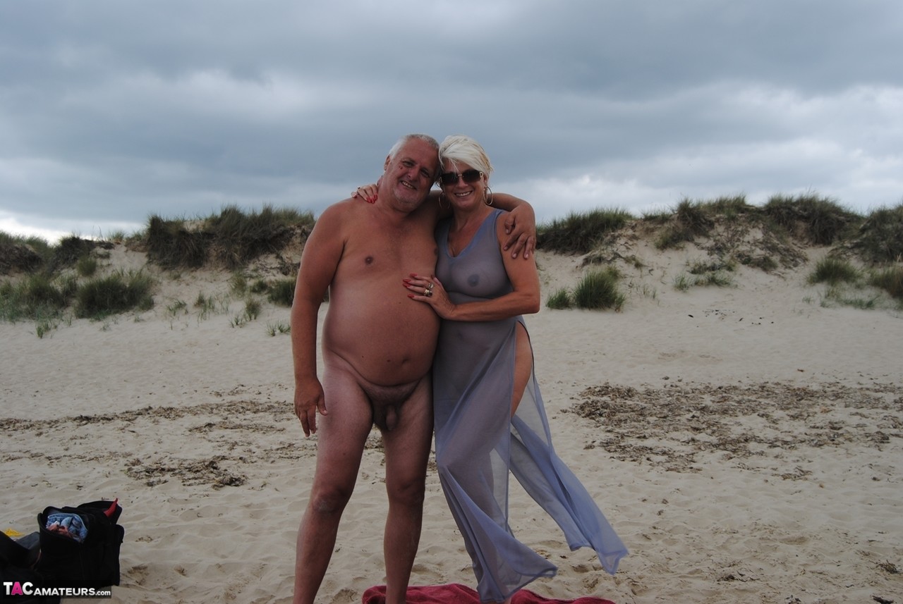 Older Platinum Blonde Dimonty Blows A Kiss While At A Nude Beach With Her Man