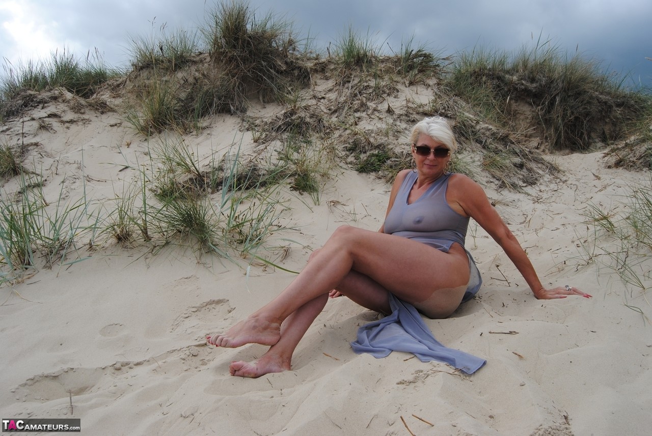 Older blonde amateur Dimonty models at the beach in see thru attire and shades foto porno #424557559