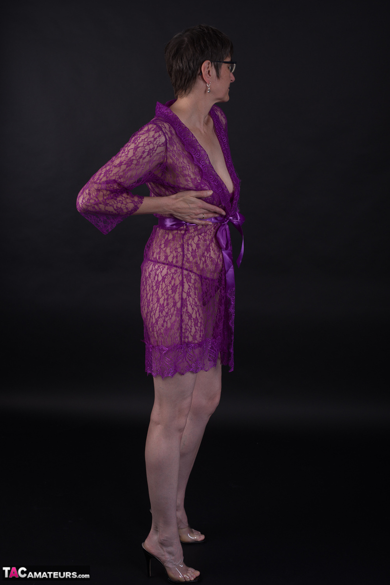 In purple lingerie, an elderly model models short hair while sporting it as a sport.