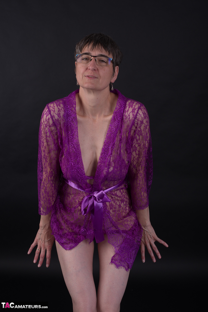 Older amateur sports short hair while modeling in purple lingerie