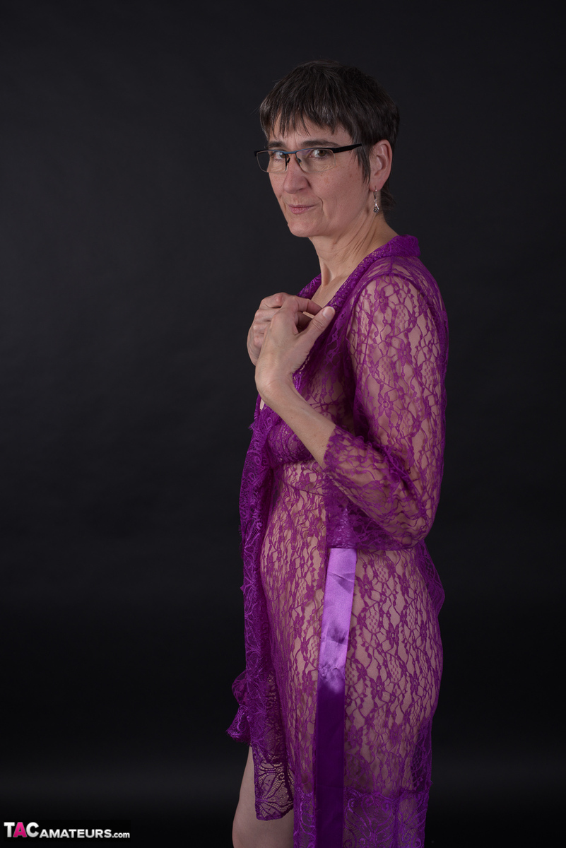 Older amateur sports short hair while modeling in purple lingerie