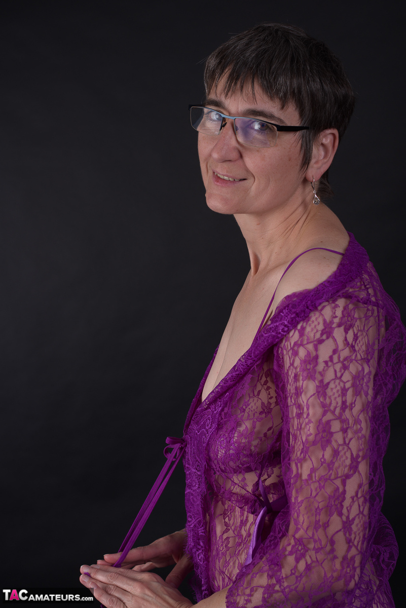 Older amateur sports short hair while modeling in purple lingerie