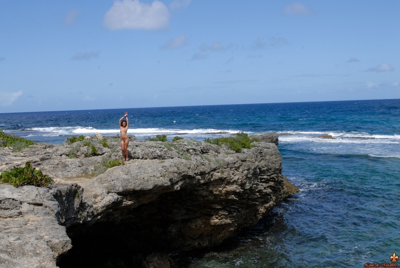 Solo model Corail removes a swimsuit to pose naked on an oceanside cliff foto pornográfica #427570033