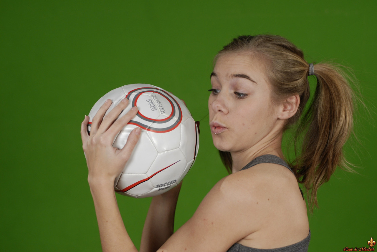 Petite girl Kelly exposes a breast while holding a soccer ball porn photo #426703895
