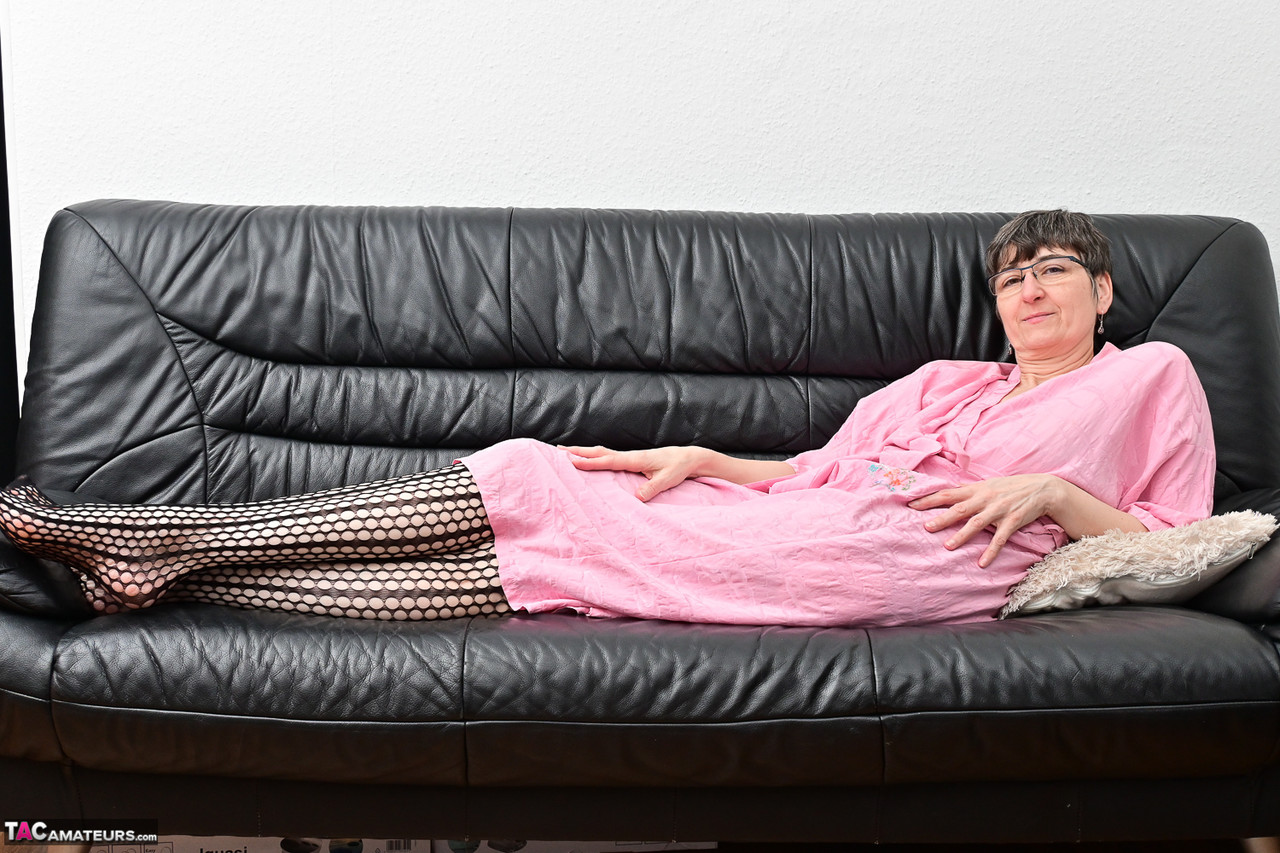 Mature woman wears glasses while masturbating with a carrot on a leather couch 포르노 사진 #428345953