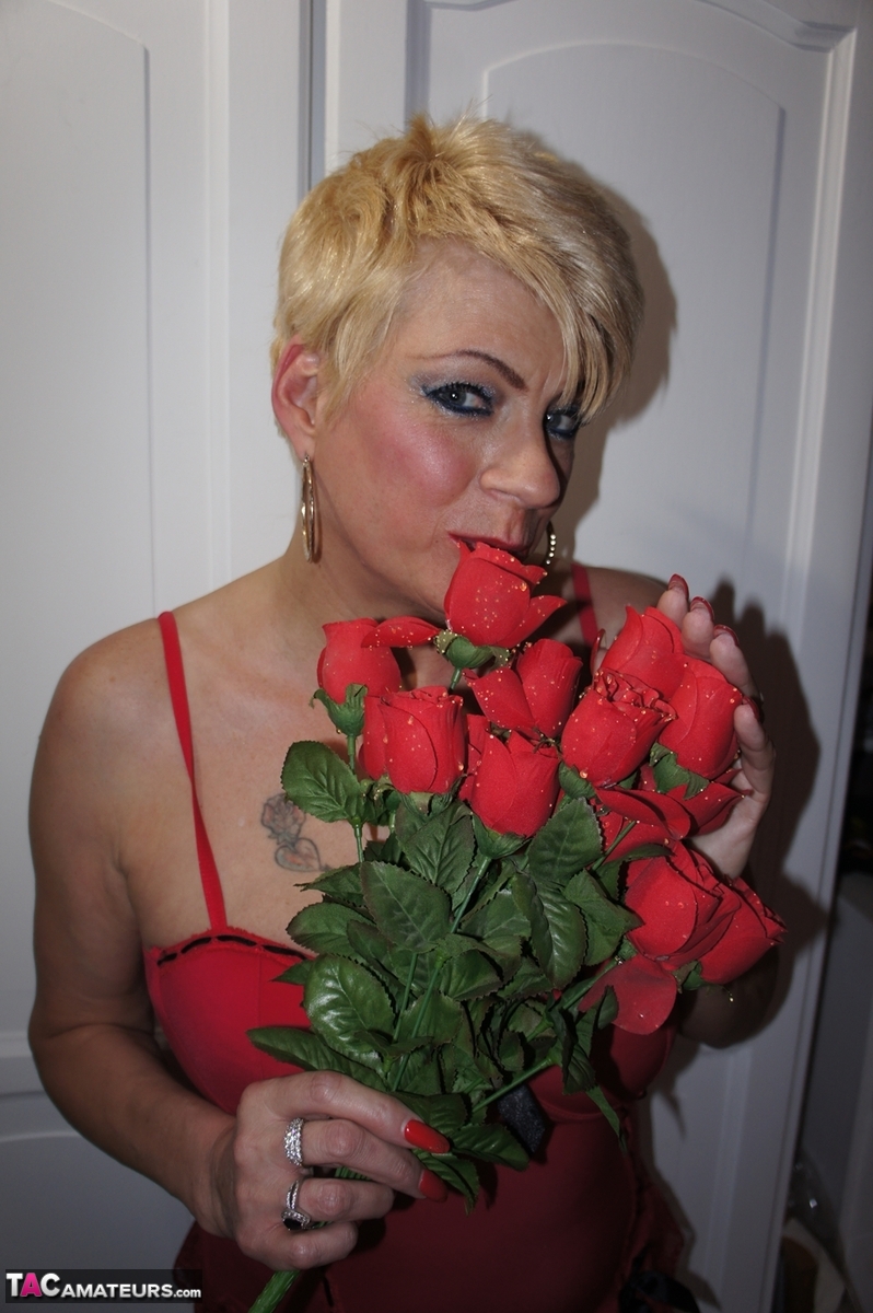 Older blonde Dimonty holds a bunch of roses while exposing her boobs foto porno #426611158