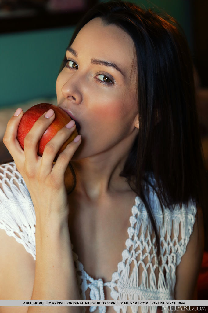 Long legged teen Adel Morel bites into an apple before modelling in the nude