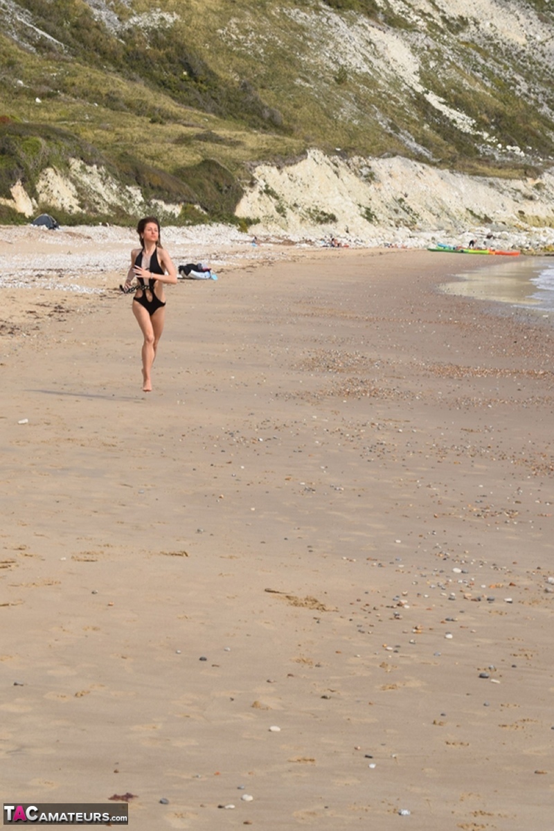 Slender female models a bathing suit while at a deserted beach foto porno #428703110