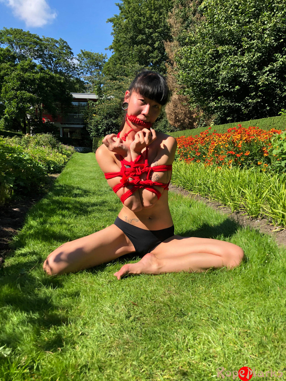 Asian Girl Flawless Meow Is Tied Up With Rope On A Lawn While Gagged