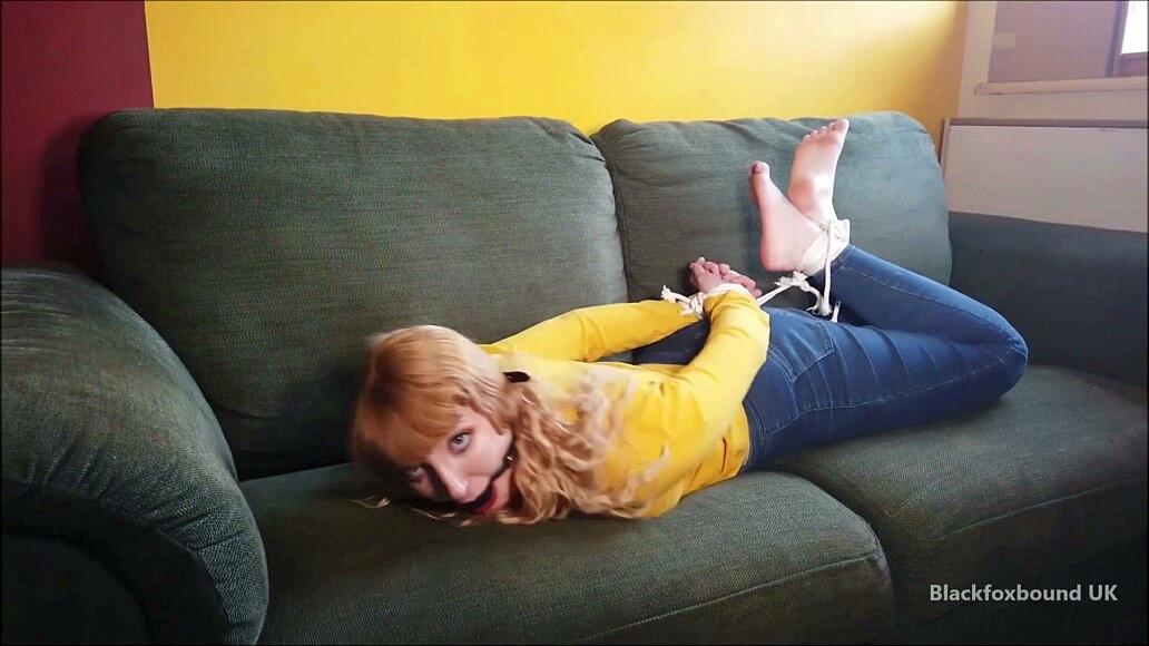 Barefoot white girl is hogtied on a sofa while ball gagged in her clothing 色情照片 #425132878
