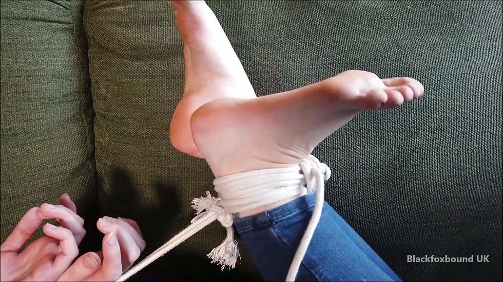 Barefoot white girl is hogtied on a sofa while ball gagged in her clothing foto porno #424747263