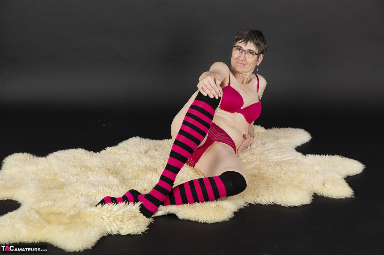 Mature woman removes her bra and underwear to pose nude in striped knee socks ポルノ写真 #428784753