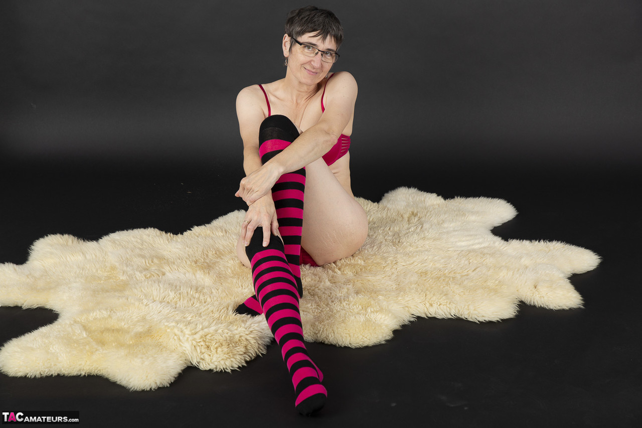 Mature woman removes her bra and underwear to pose nude in striped knee socks ポルノ写真 #428784755