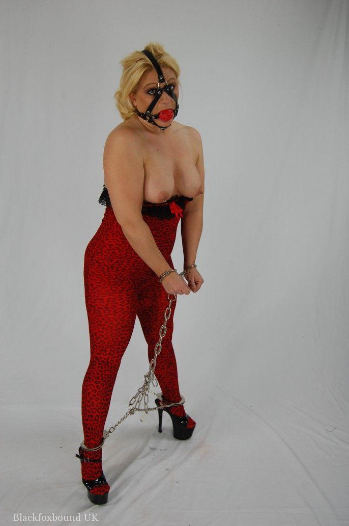 Before sucking, the blonde is held in chains and subjected to a ball gag for several minutes.