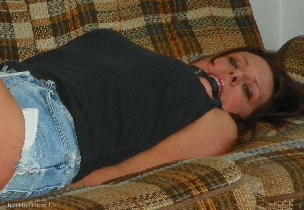 Redhead is gagged while cuffed and hogtied on a futon in denim shorts photo porno #425128692
