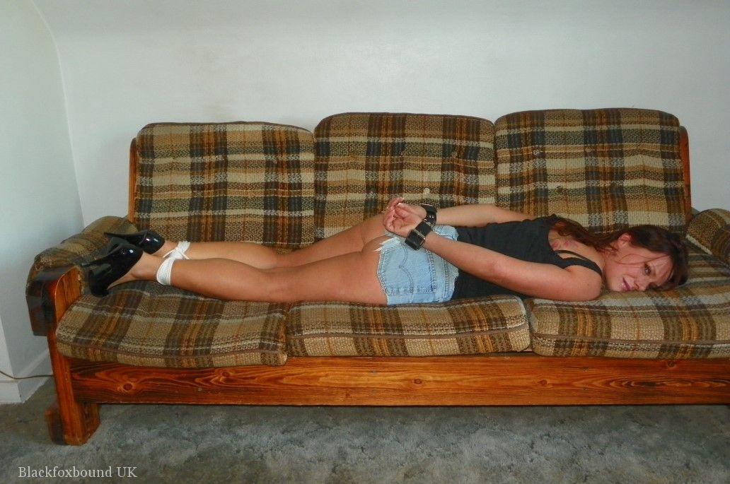 Redhead is gagged while cuffed and hogtied on a futon in denim shorts порно фото #425128703