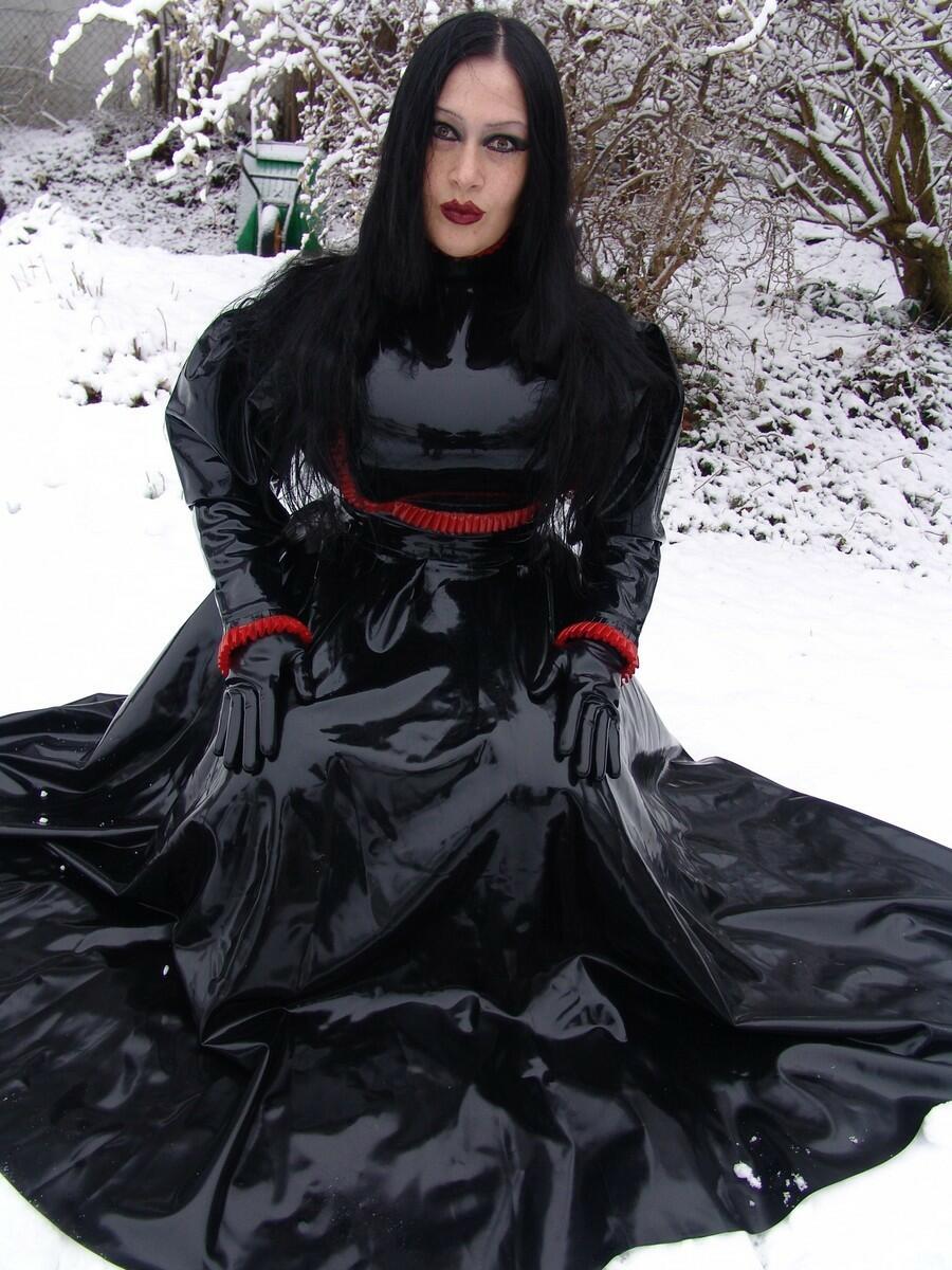 Goth woman Lady Angelina models a black latex dress on snow-covered ground porn photo #423838483