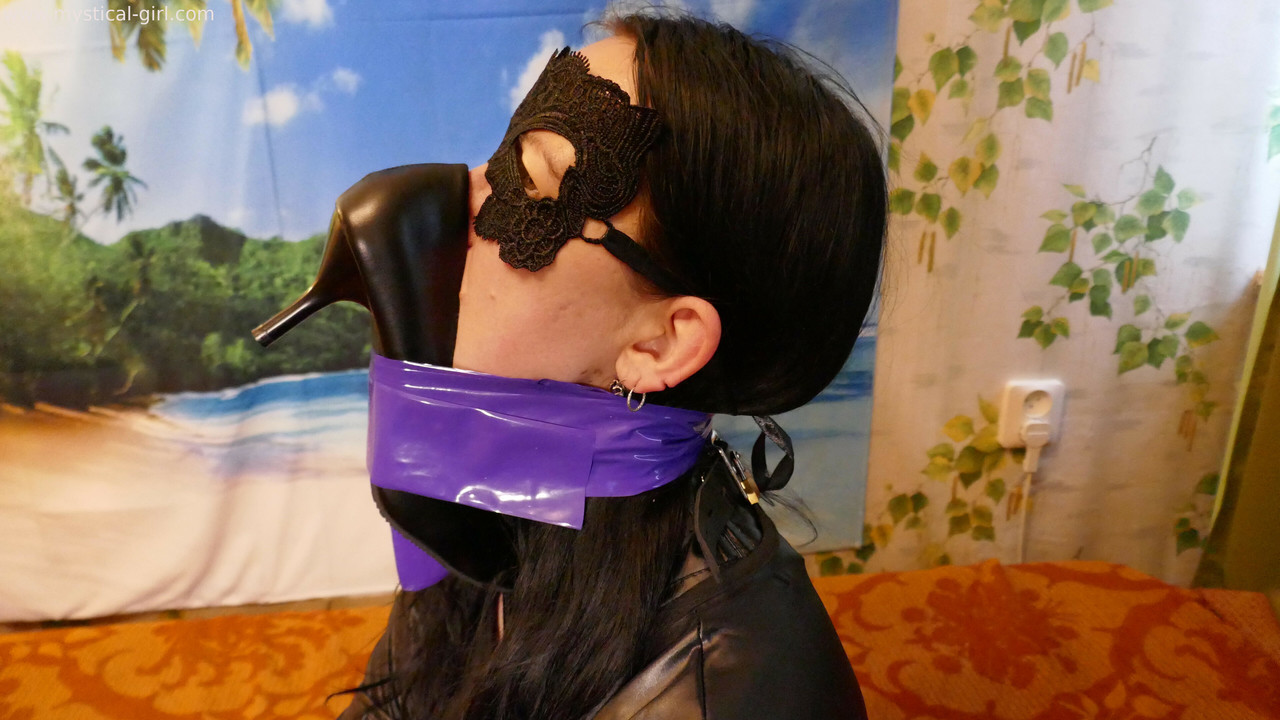 Caucasian woman sports a mask while modelling leather clothing and footwear foto porno #425912719