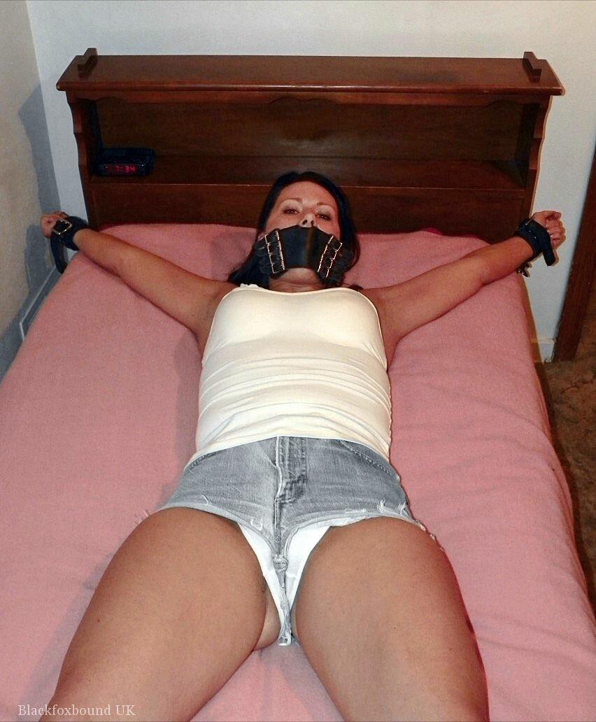 With her cleavage and boottied body, the solo girl is seen on a bed wearing denim cutoffs.