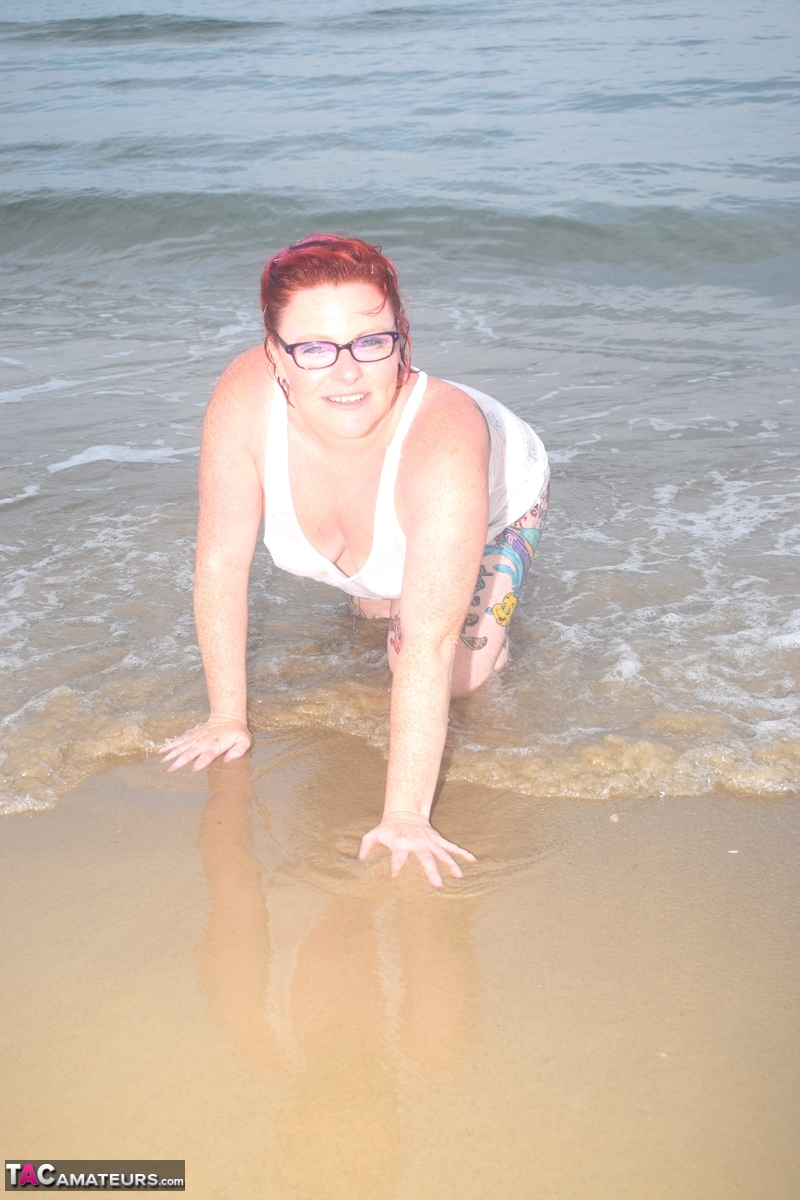 The tattooed redhead floats into the ocean before exposing herself.