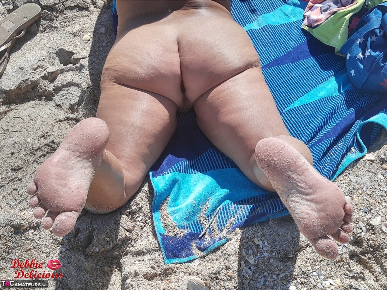 Older amateur Debbie Delicious sunbathes in shades on a nude beach porn photo #426813788