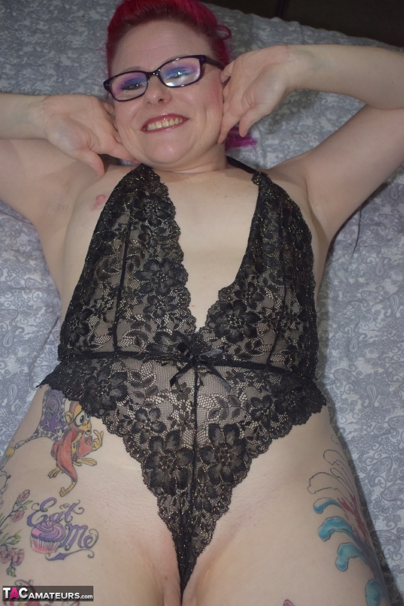 The tattoo-wearing amateur, Mollie Foxxx (pictured), poses with her glasses on and bares black lingerie.