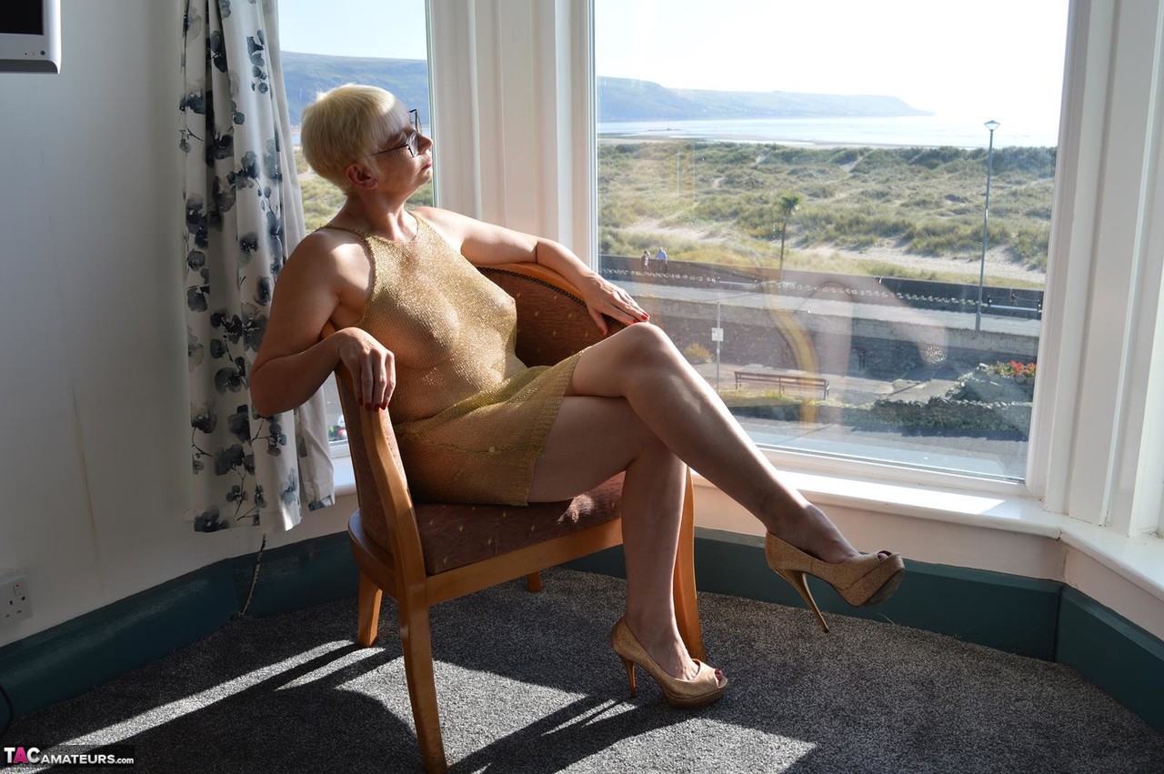 Big titted older woman Barby Slut showcases her bald twat in front of a window porn photo #424802940