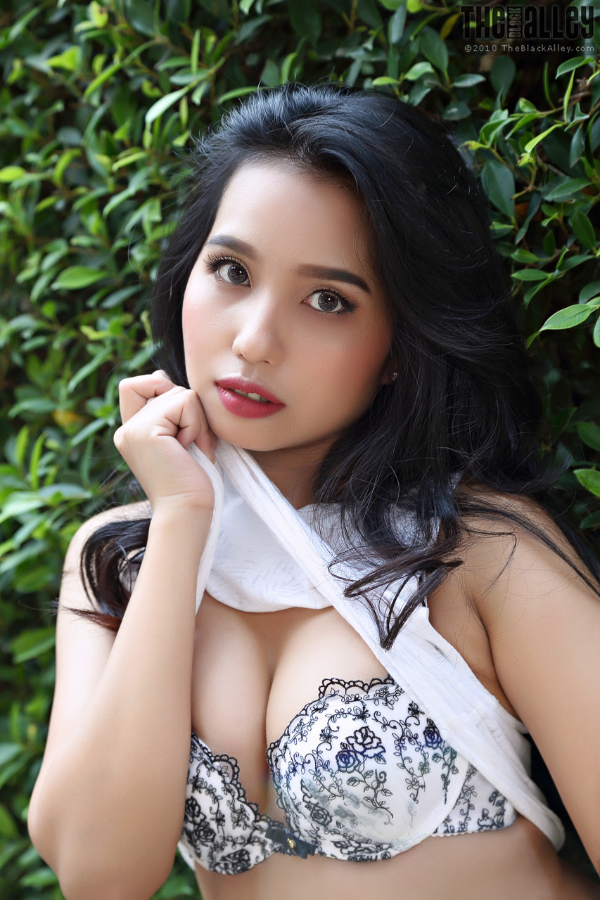 Beautiful Asian girl Norah gets totally naked next to a hedge in a garden porn photo #423793733