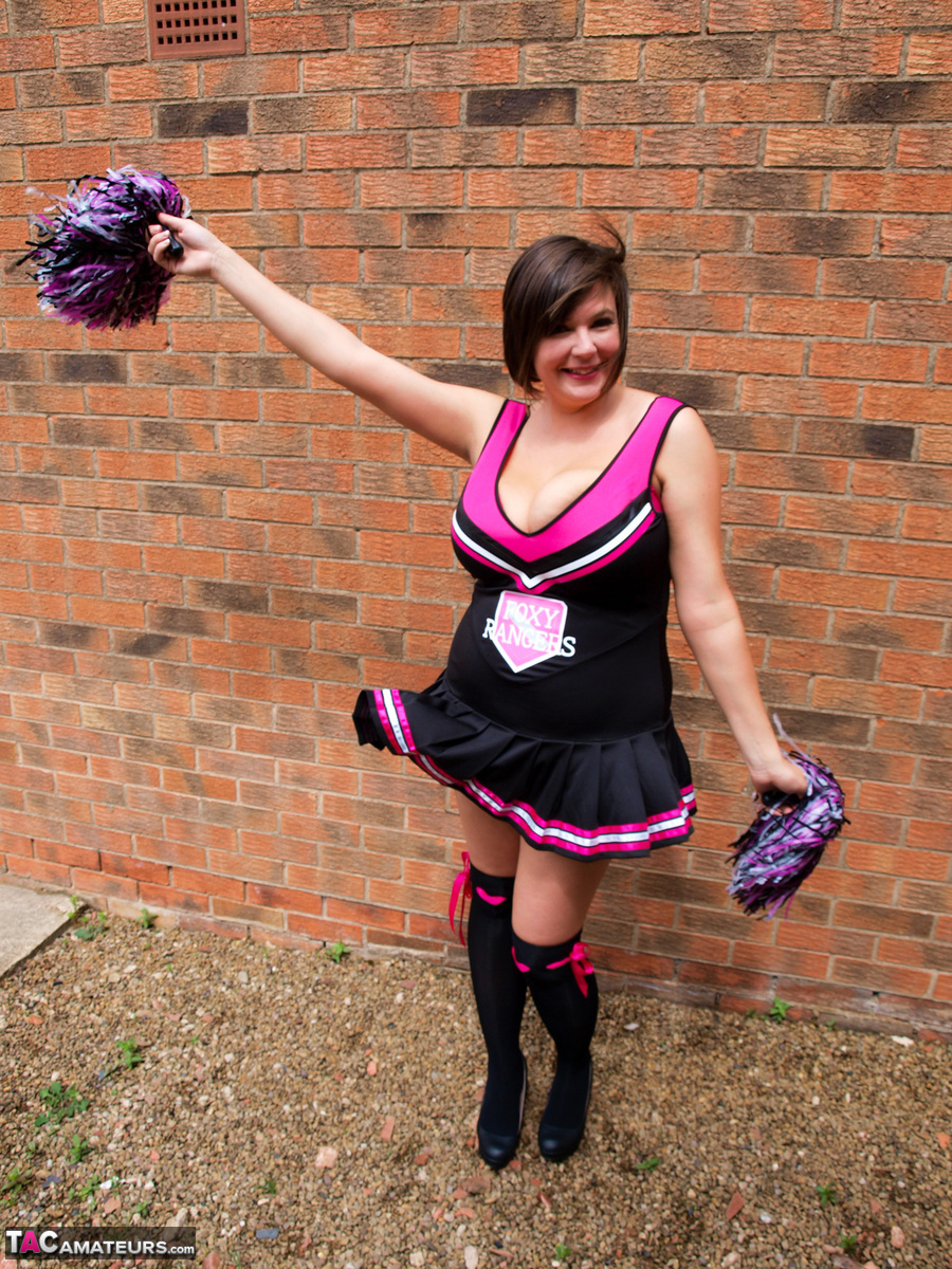 Chubby cheerleader Roxy uncovers her large tits against a brick wall porn photo #422803479