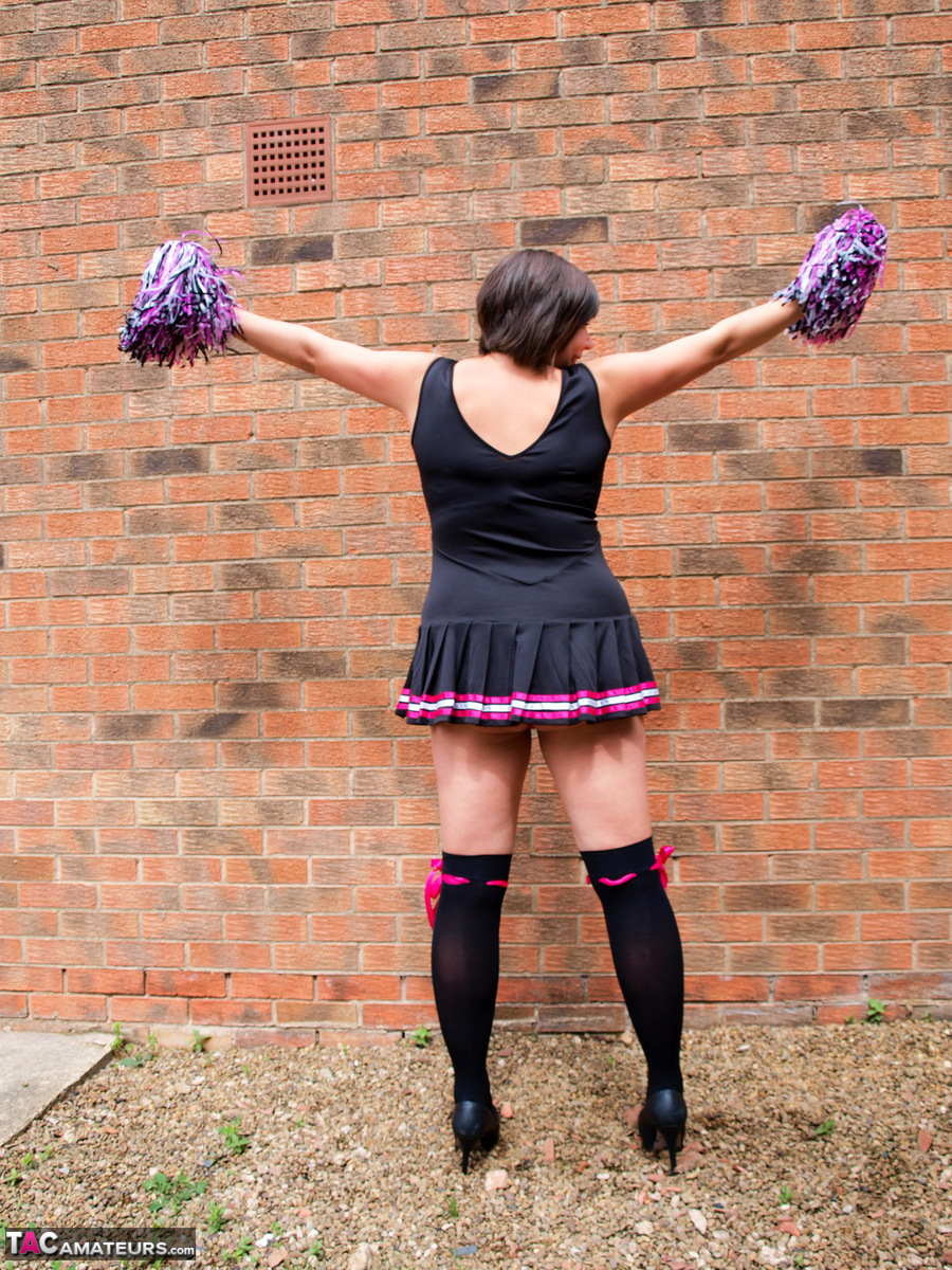 Chubby cheerleader Roxy uncovers her large tits against a brick wall foto porno #422803477