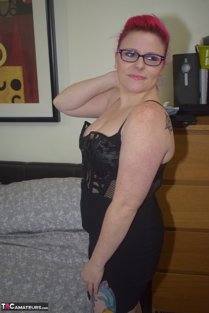 Tattooed redhead Mollie Foxxx dildos her vagina on a bed in glasses and heels foto porno #427300864