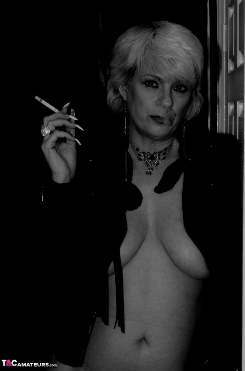 Older blonde lights a cigarette while showing her bare breasts and pussy foto porno #424106435