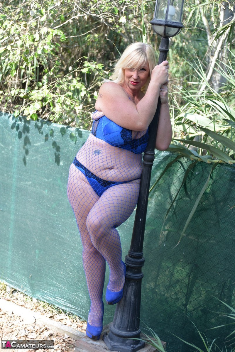 Blonde granny Melody touches her huge tits outdoors in a mesh bodystocking porn photo #424617576