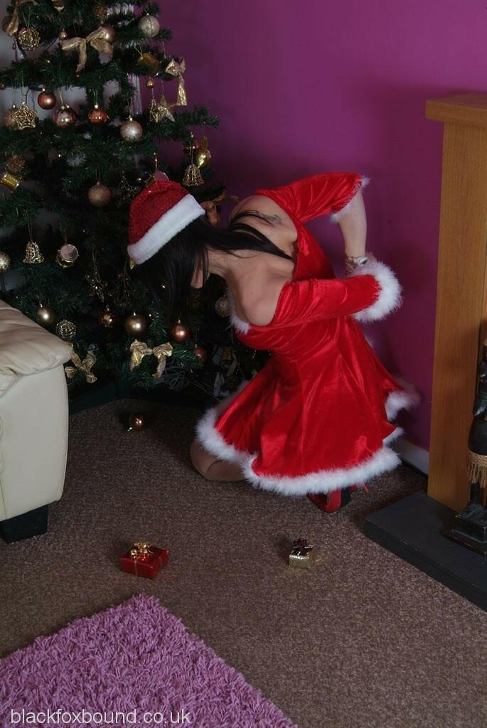 Dark-haired female Erin removes a ball gag while bound up at Christmas porn photo #424909418