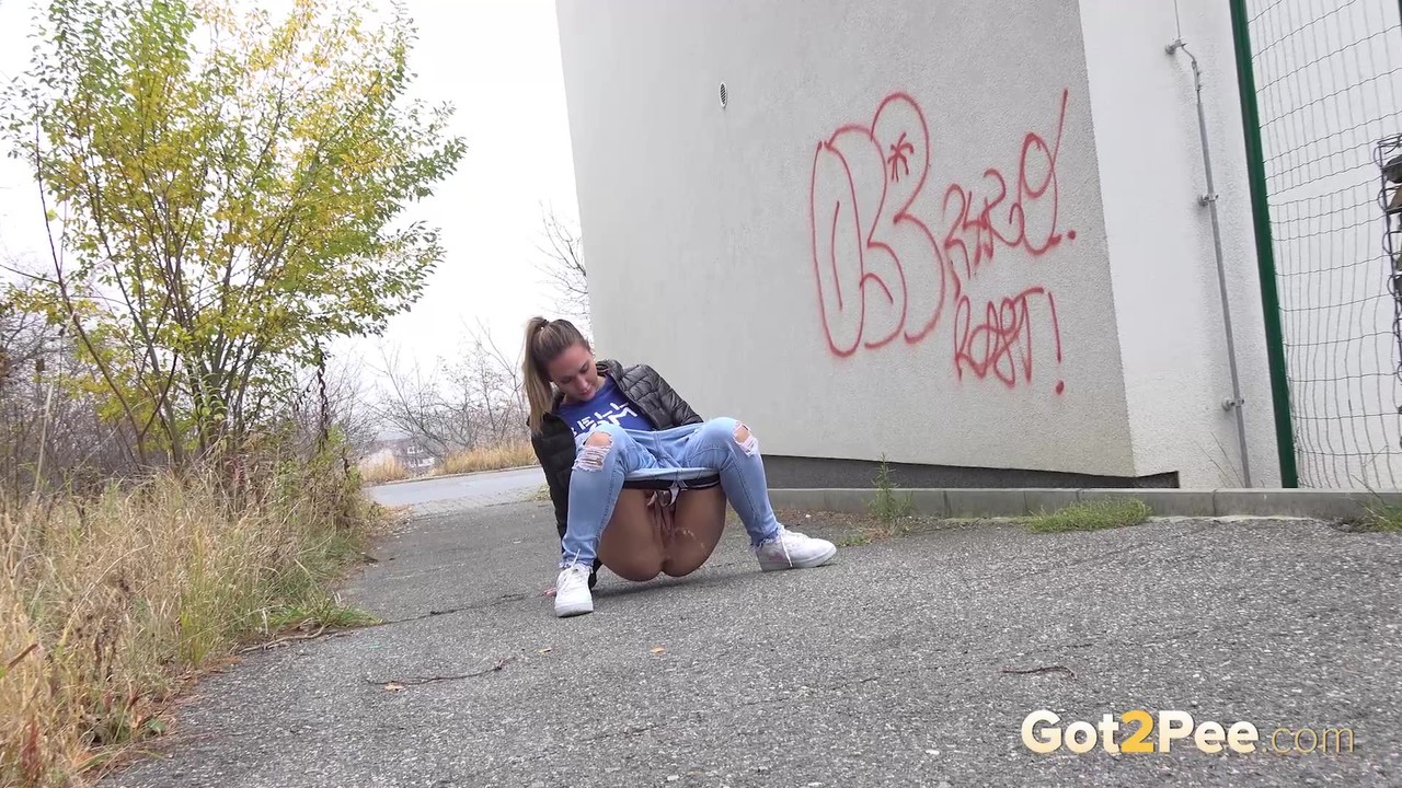 Czechoslovakian female Naomi Bennet takes a pee on pavement beside a building porno foto #427998611
