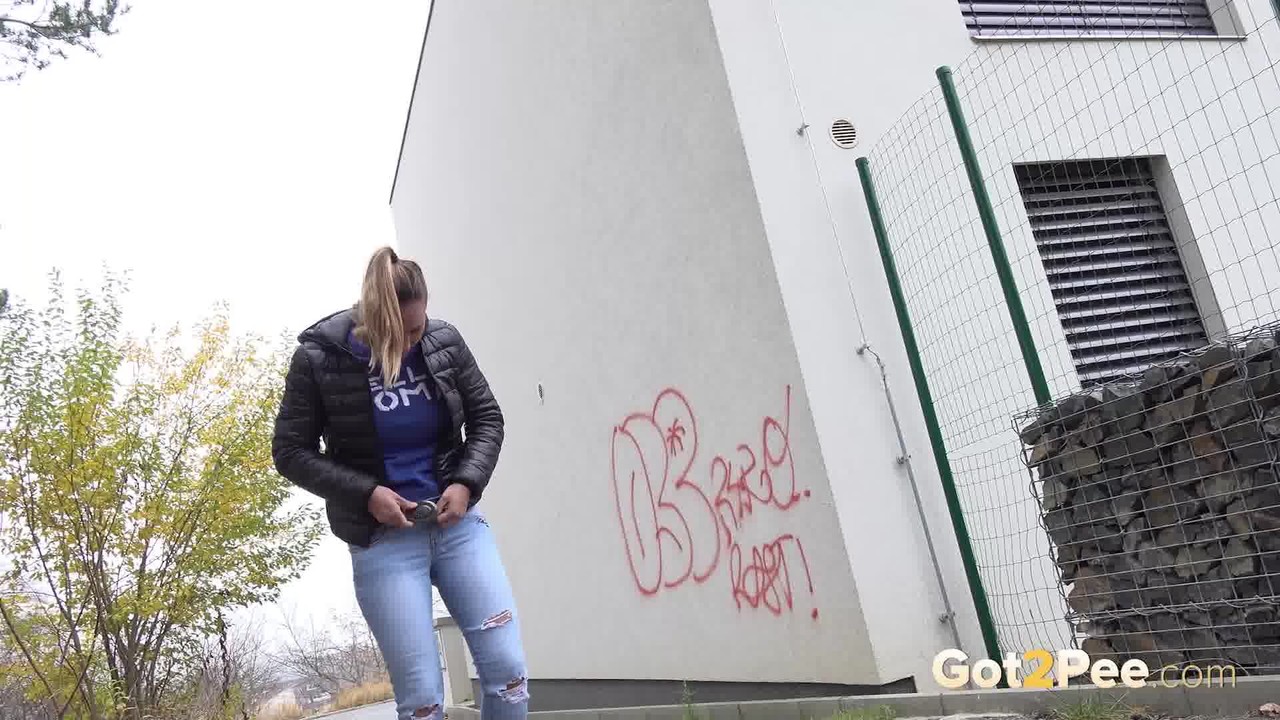 Czechoslovakian female Naomi Bennet takes a pee on pavement beside a building porn photo #427998635