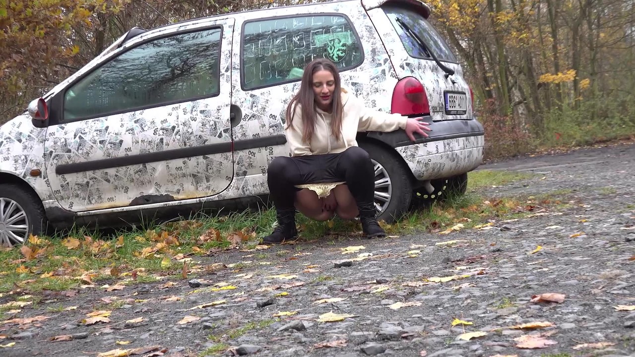 White girl Nicolette Noir takes a piss beside a parked car in a wooded setting foto porno #427213962