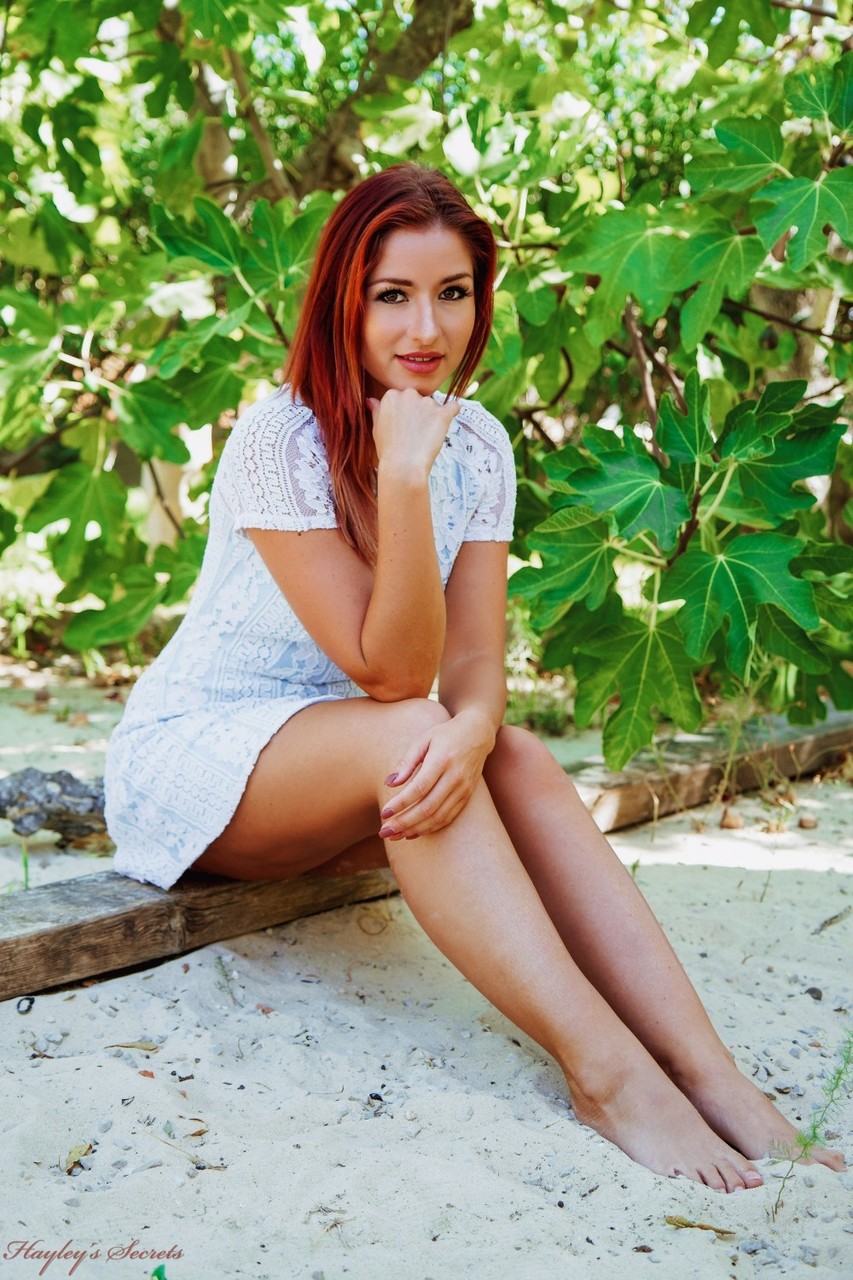 Redheaded beauty Harley Gacke strips naked in a garden setting порно фото #425742178