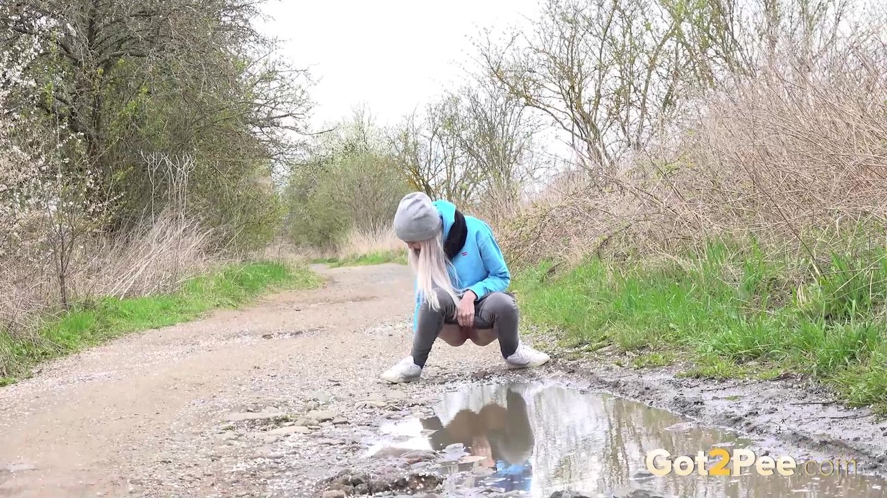 Blonde girl Mistica pees in a puddle on a dirt road through the countryside foto porno #425329045
