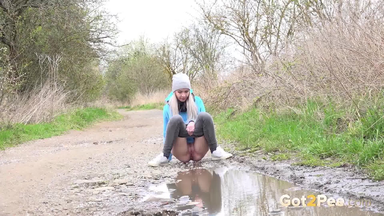 Blonde girl Mistica pees in a puddle on a dirt road through the countryside photo porno #425329063