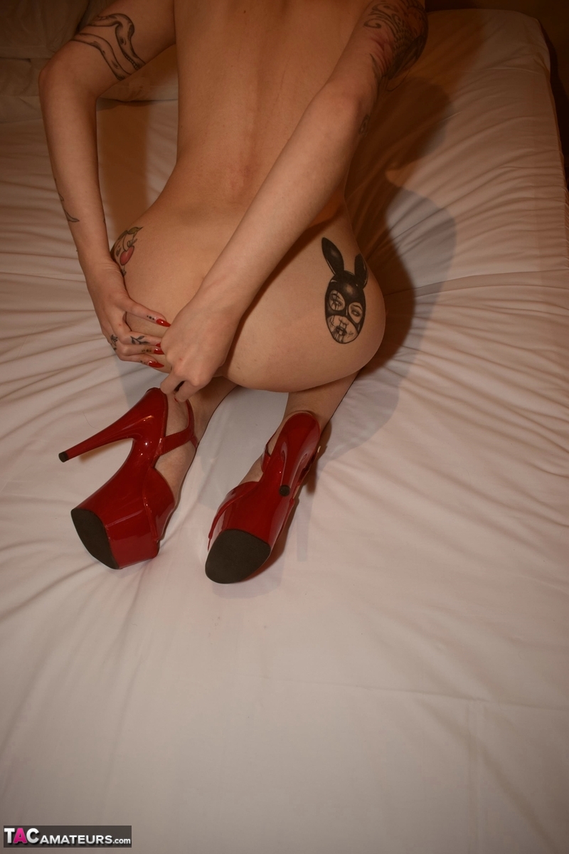 Tattooed blonde masturbates with a pink vibrator on a bed in red heels foto porno #426714993