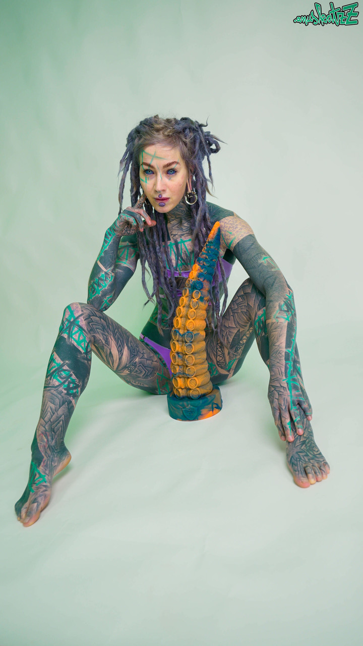Heavily tattooed girl Anuskatzz holds a couple of taintacle toys in the nude porn photo #422703593