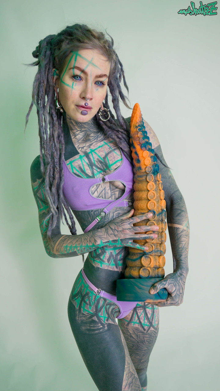 Heavily tattooed girl Anuskatzz holds a couple of taintacle toys in the nude Porno-Foto #422703665