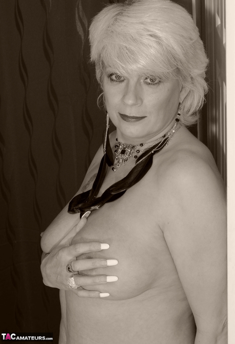 Old blonde Dimonty fondles her own breasts while wearing stockings without any top on.