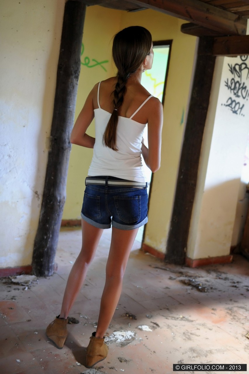 Skinny chick takes off her denim shorts to pose naked against graffiti porn photo #424124223