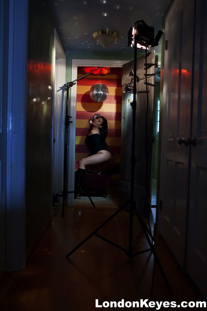 London Keyes, an Asian solo girl, displays her tits and movements by placing it near a payphone.