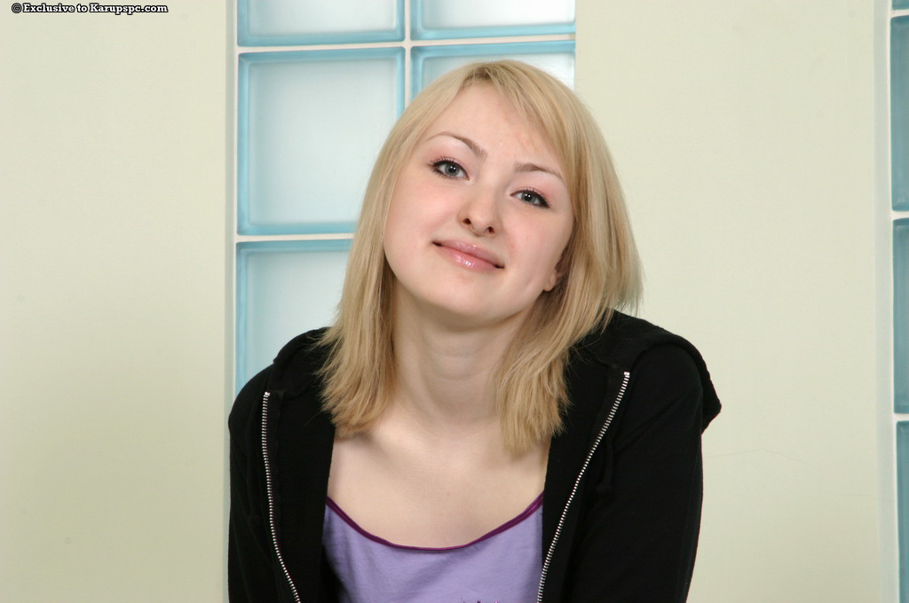 A playful blonde girl in white socks undressing and exposing her hairstyling slit.