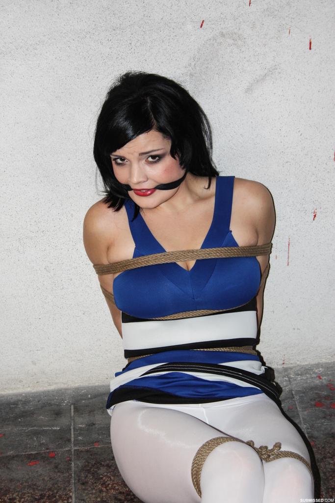 Rope bound and gagged leave the woman with dark hair helpless.